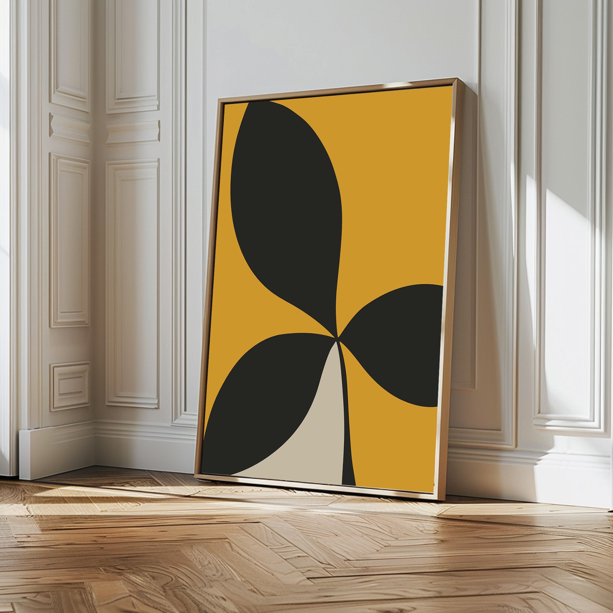 The Botanic Contrast Abstract Canvas Art features bold black and beige petal shapes on a mustard yellow background, framed and displayed against a white paneled wall—an ideal minimalist touch for modern living room decor.