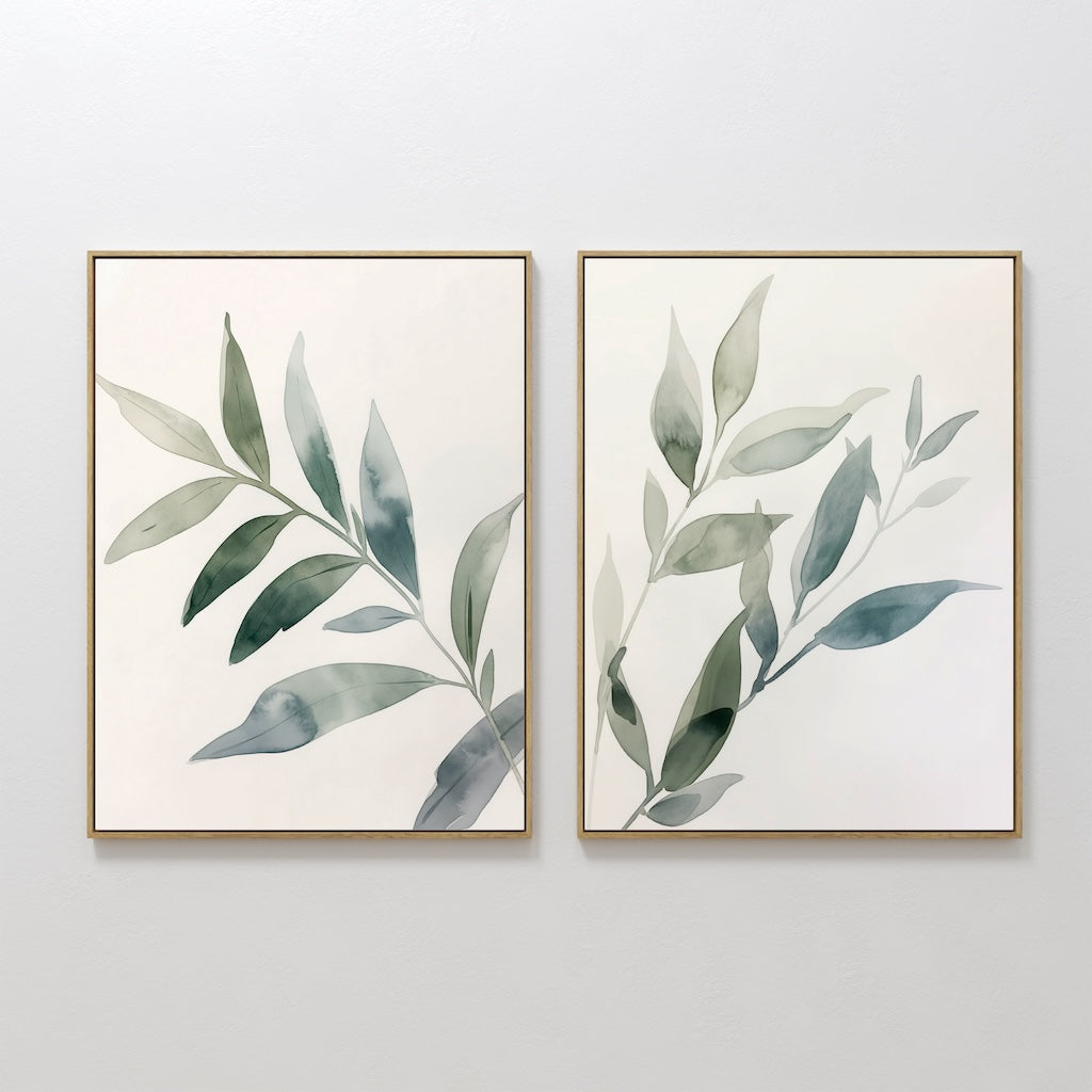 The Botanical Breeze Set of 2 features framed watercolor paintings of leafy branches in soft green and blue, displayed side by side. This minimalist wall art set brings a touch of nature to your decor.