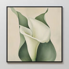 Calla Duo Canvas Art showcases two white calla lilies with green leaves on a light beige backdrop, softly blended and framed in sleek black—ideal for modern decor and creating a serene floral wall art display.