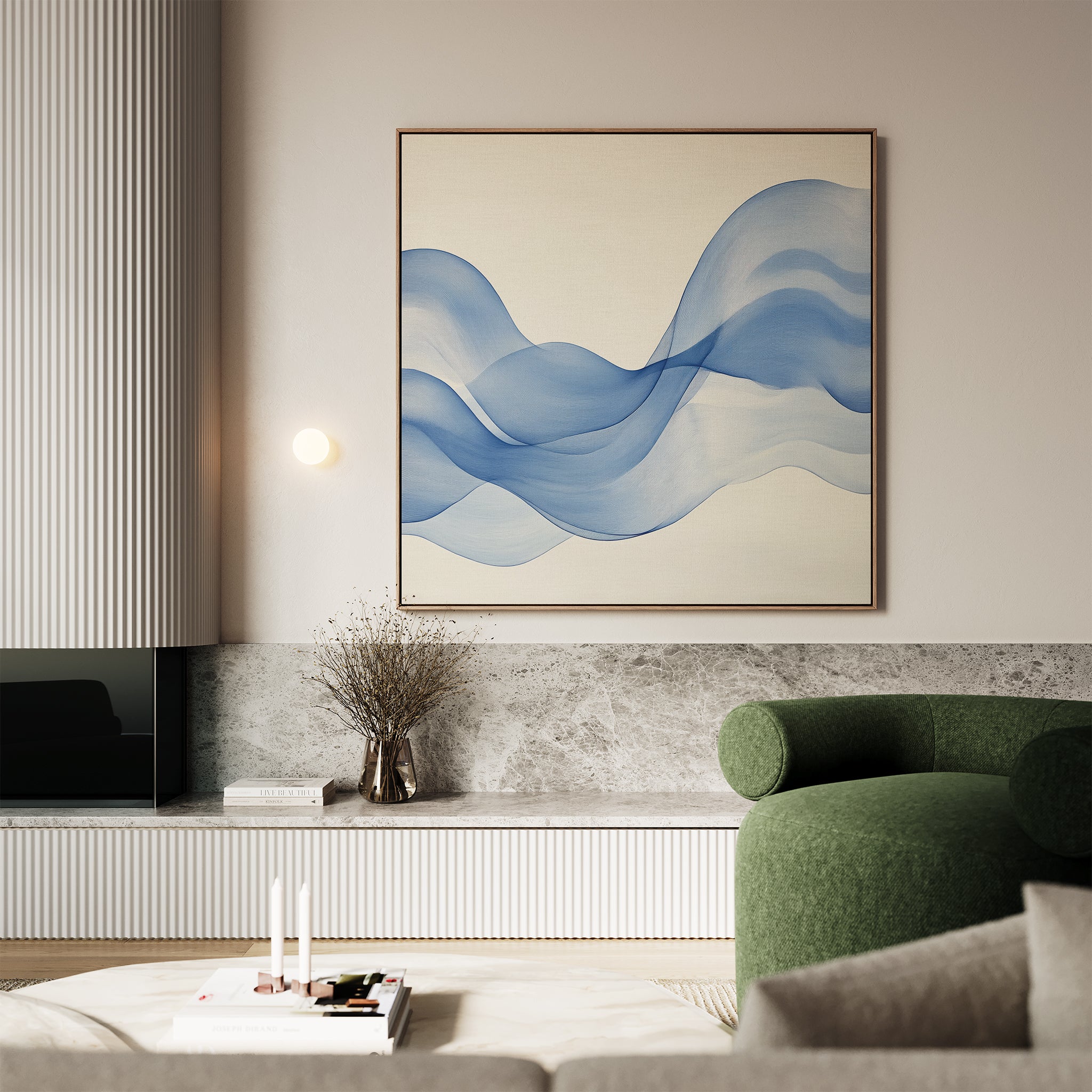 A modern living room features a green armchair, marble accents, and the Calm Swell Canvas Art—a large abstract wall print of flowing blue waves—above a shelf with a vase and books, creating stylish and serene décor.