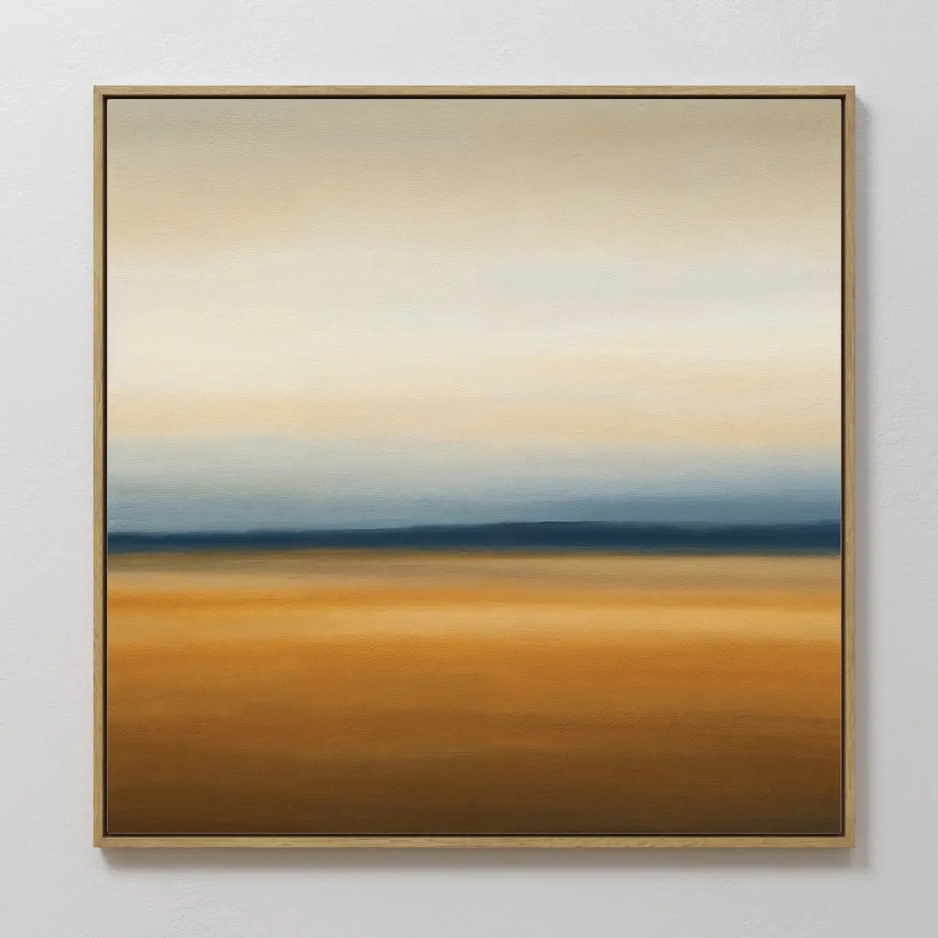 Caramel Plains Canvas Art features warm golden-brown layers, a blue-gray band, and soft white-beige tones, all framed in a slim golden frame—an ideal abstract wall art piece for modern bedroom decor.