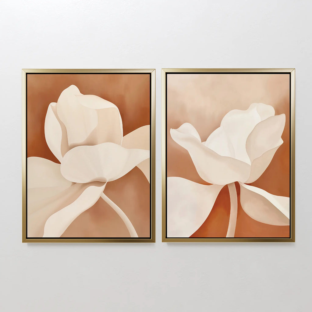 The Clay Blossom Set of 2 features framed abstract floral wall art prints with large cream and beige flowers on a warm brown background, displayed side by side on a plain white wall.
