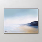 The Cliffside Light Canvas Art – Horizontal features a tranquil coastal scene with sandy beach, soft waves, and distant cliffs beneath a misty blue sky—ideal for adding a serene touch to any bedroom.
