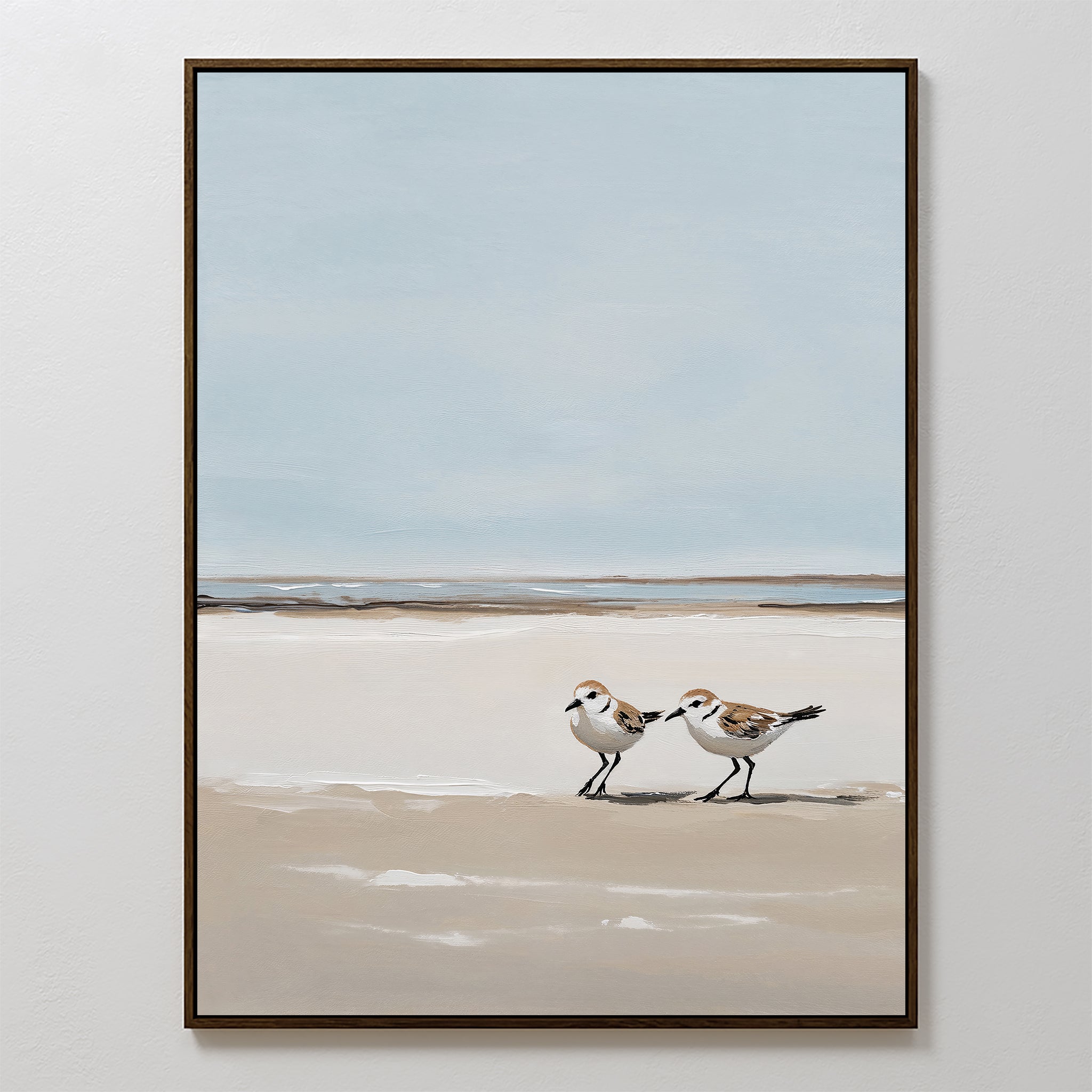Coastal Chase Canvas Art features two small shorebirds strolling on a sandy beach with sea and sky beyond; soft, neutral tones create a calm, minimalist look—an ideal wall art print for a peaceful space.