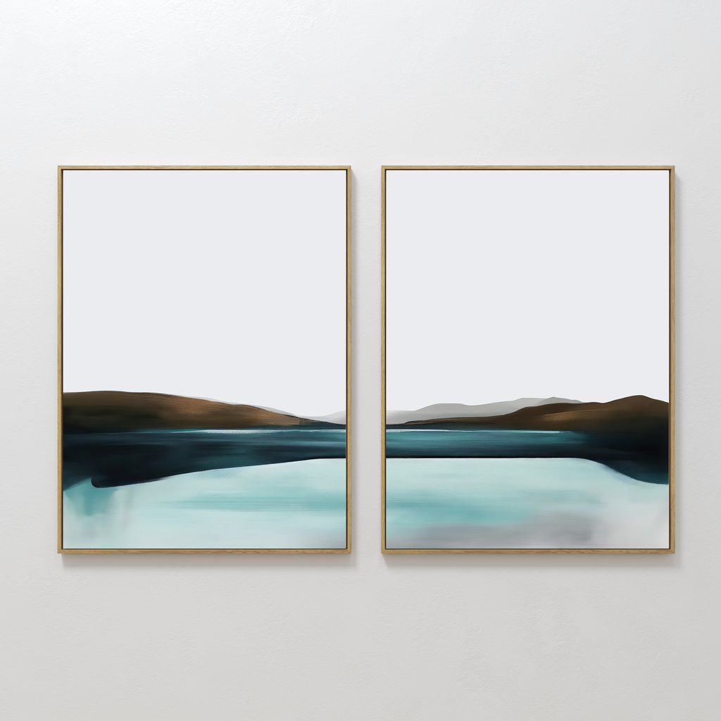The Coastal Calm Set of 2 features framed abstract landscape paintings with cool tones, showing a serene body of water and distant hills, displayed side by side on a white wall.