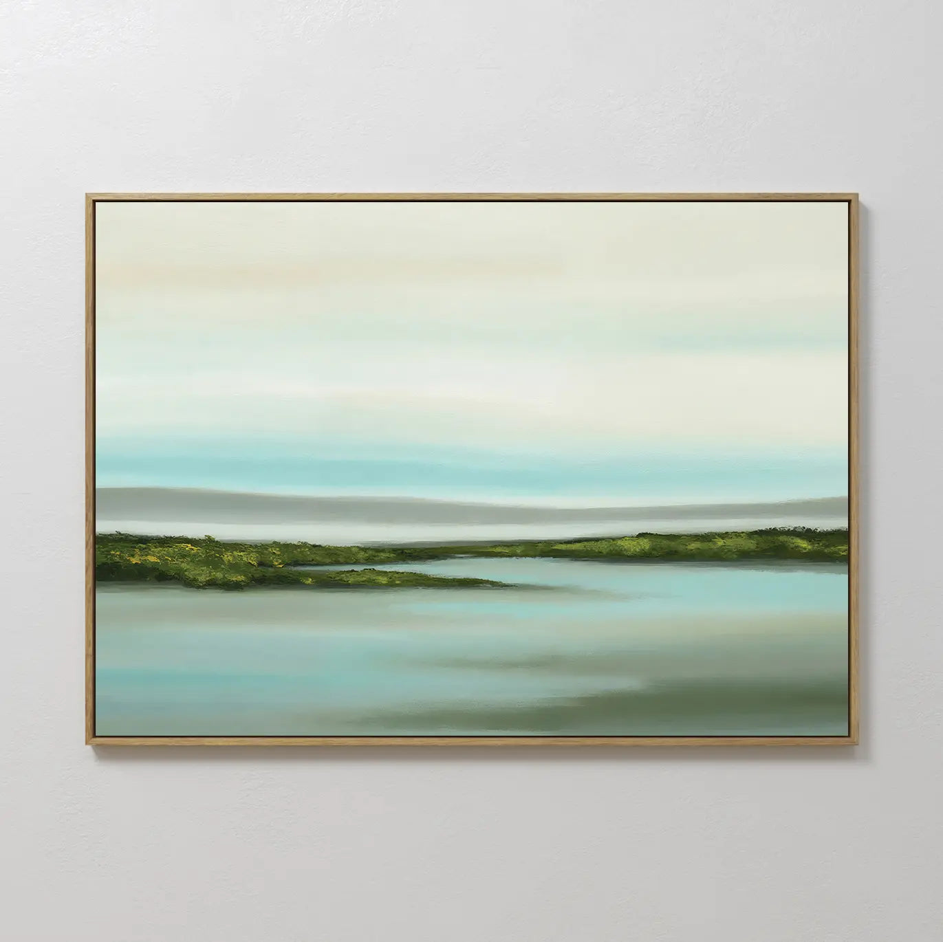 Coastal Marsh Canvas Art is a framed minimalist wall piece showcasing green fields, calm blue water, and a pale layered sky—ideal landscape wall art for bedroom decor on light-colored walls.