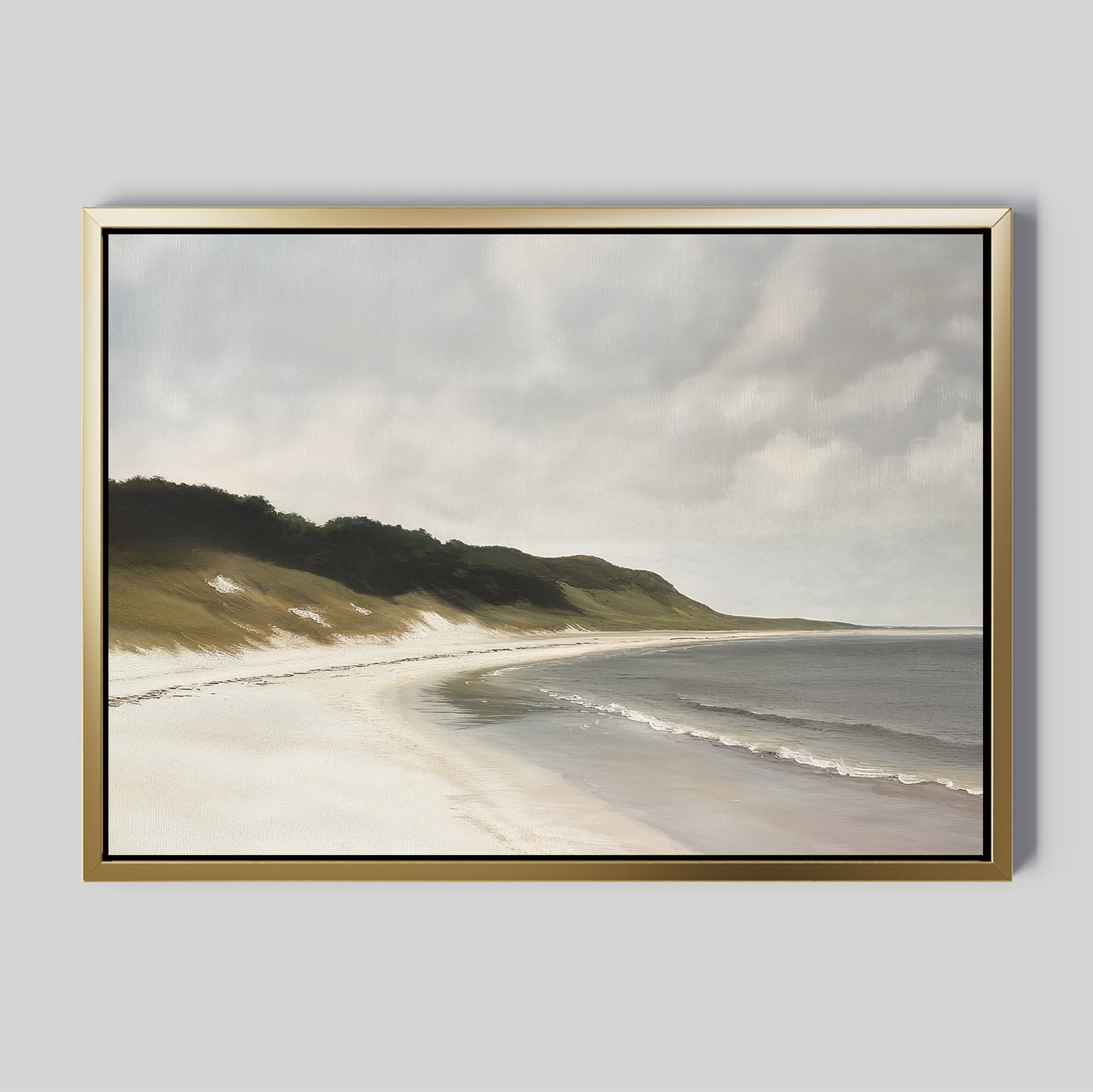 The Coastal Silence Canvas Art features a serene beach with gentle waves, sandy shore, grassy dunes, and a cloudy sky, all framed and displayed against a plain light gray background.