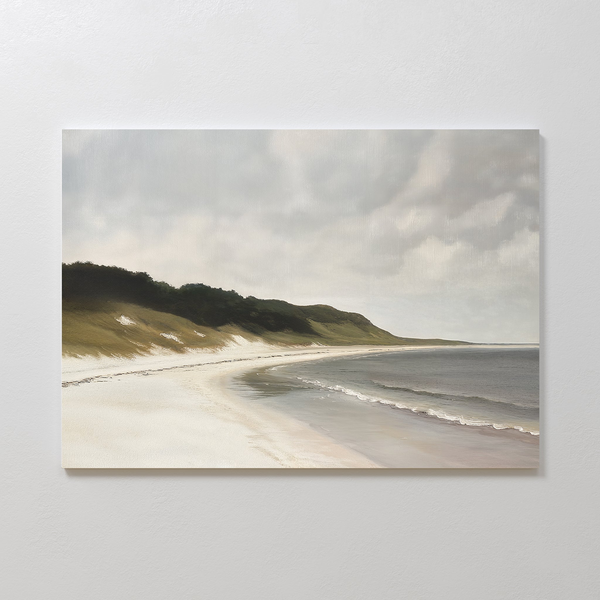 The Coastal Silence Canvas Art showcases a serene sandy beach with gentle waves, grassy dunes, and a cloudy sky, creating calming coastal wall art for your home.