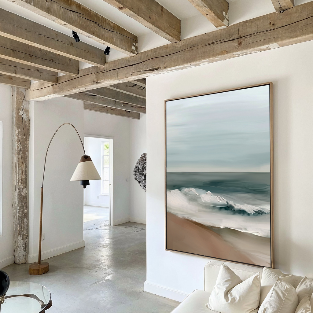 A modern living room with exposed wooden ceiling beams features the Coastal Whisper Abstract Canvas Art on a white wall, complemented by a curved floor lamp and neutral minimalistic furniture. Natural light streams in from the adjacent room.