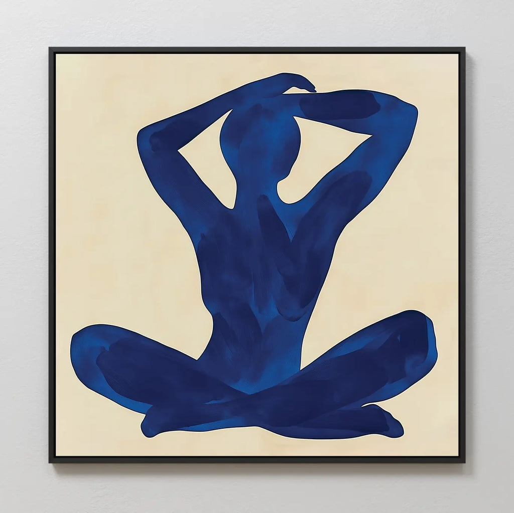 Cobalt Figure Canvas Art: Minimalist canvas with a blue silhouette of a seated figure, legs crossed and arms raised behind the head on a beige background in a black frame—a stylish touch for modern wall decor.