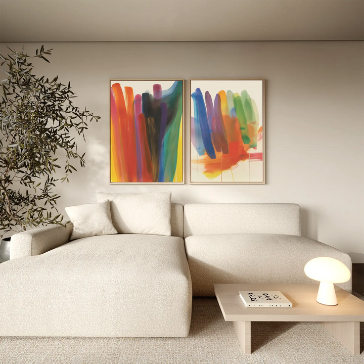 A modern living room with a light beige sectional sofa, wooden coffee table, indoor tree, and the Color Cascade Set of 2 abstract wall art pieces adding vibrant charm to the decor.