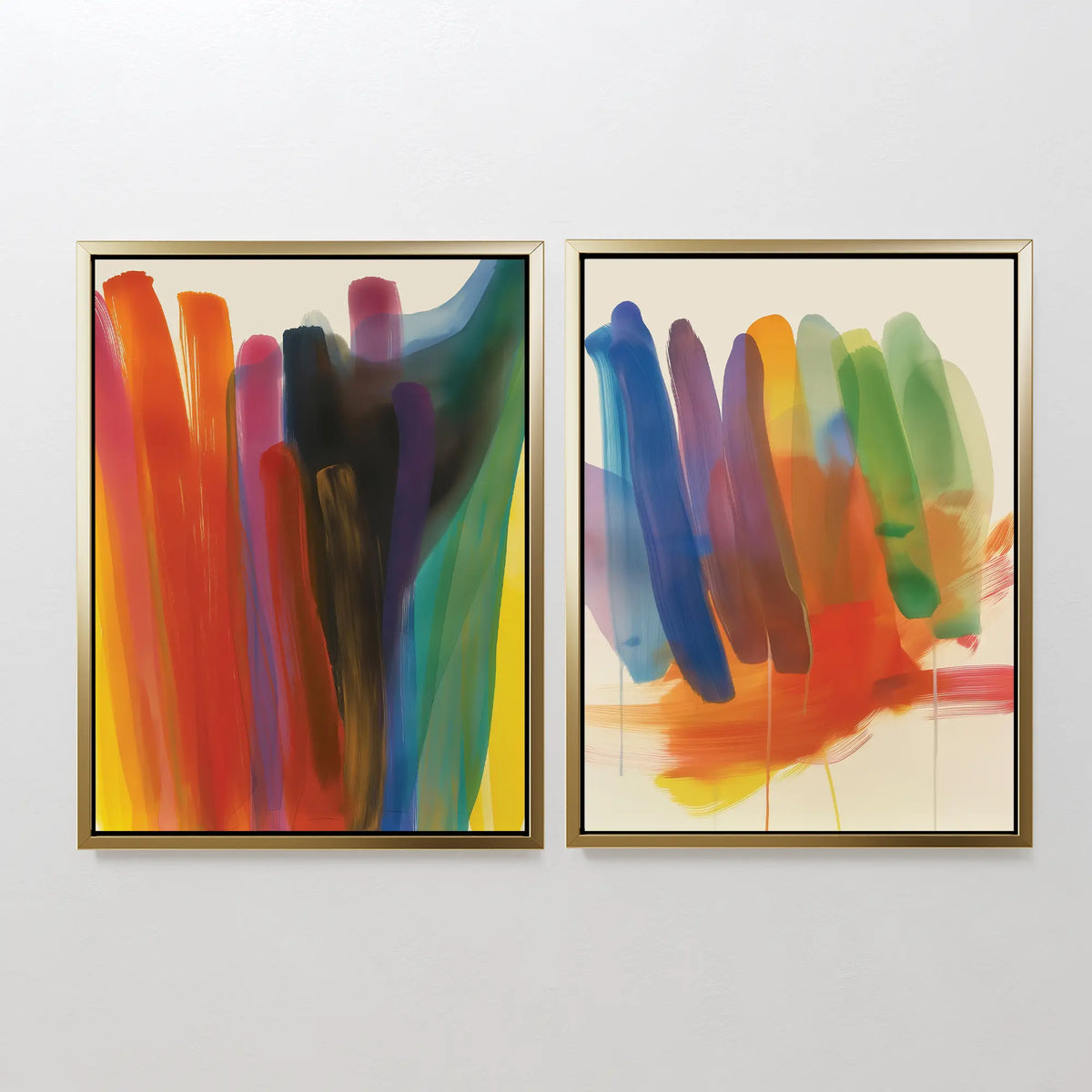 The Color Cascade Set of 2 features framed abstract wall art with wide, colorful brushstrokes—reds and yellows on the left, vibrant blues and greens on the right—adding a bold modern touch to any white wall.