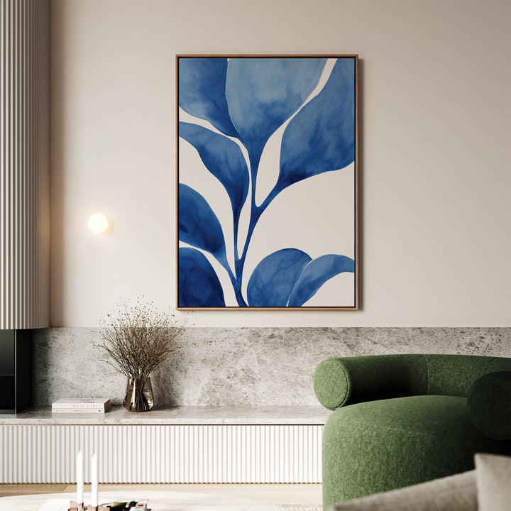 A modern living room with a green curved sofa, a marble-topped bench, a vase with dried branches, and the Cool Tangle Canvas Art—abstract blue and white botanical wall art—hanging above.