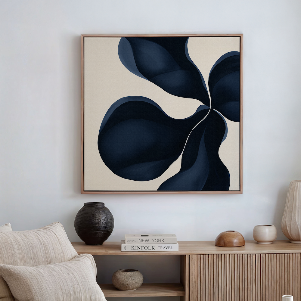 A modern interior with a wooden console, vases, and books. Above hangs the Blossom Blue Abstract Canvas Art—a framed print with bold dark blue organic shapes, perfect minimalist wall decor for contemporary spaces.