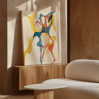 The Dance Of Unity Abstract Canvas Art, featuring flowing yellow, blue, and red shapes, sits on a wooden cabinet next to a white textured sofa and round table in a bright modern living room.