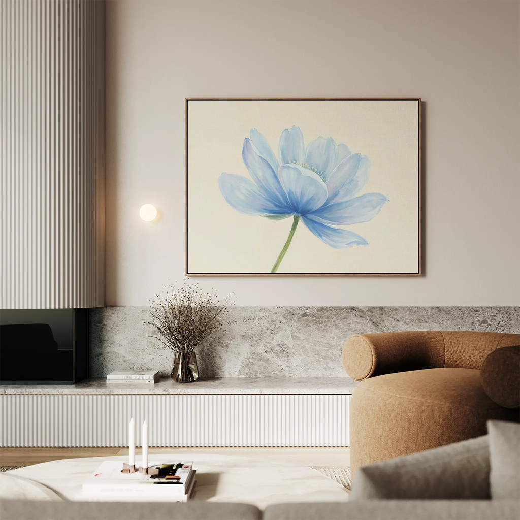 A modern living room with neutral tones features the Daybreak Flower Canvas Art above a stone shelf, complemented by sleek decor, a round brown chair, and soft ambient lighting.