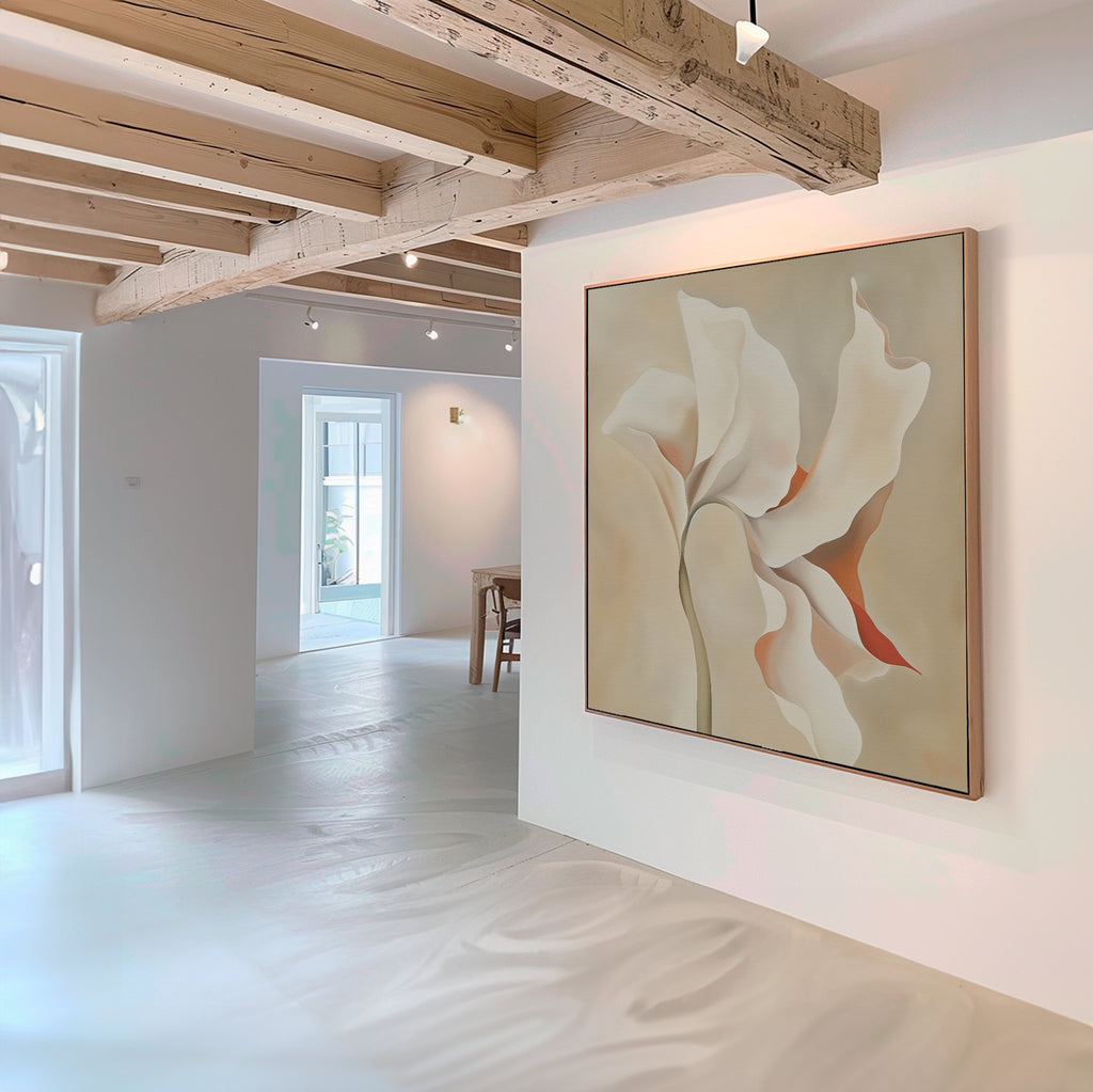 A modern, minimalist living room with white walls and exposed wooden beams features the Delicate Bloom Abstract Canvas Art in soft beige and tan tones. Natural light enhances the contemporary elegance of this decor.