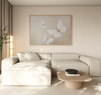 A modern living room with a light beige sectional sofa, low wooden coffee table, and the Delicate Whites Canvas Art. Soft natural light fills the Nordic Park-inspired space, enhancing its neutral tones and minimal decor.