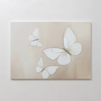 Delicate Whites Canvas Art features three white butterflies with translucent wings on a soft beige background, adding gentle movement and elegance—perfect neutral wall decor for any Nordic Park-inspired space.