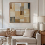 A modern living room with a beige sofa, neutral pillows, dried flowers in a vase, a table lamp, and the Desert Mosaic Abstract Canvas Art featuring tan, cream, and brown geometric patterns hanging on the wall.