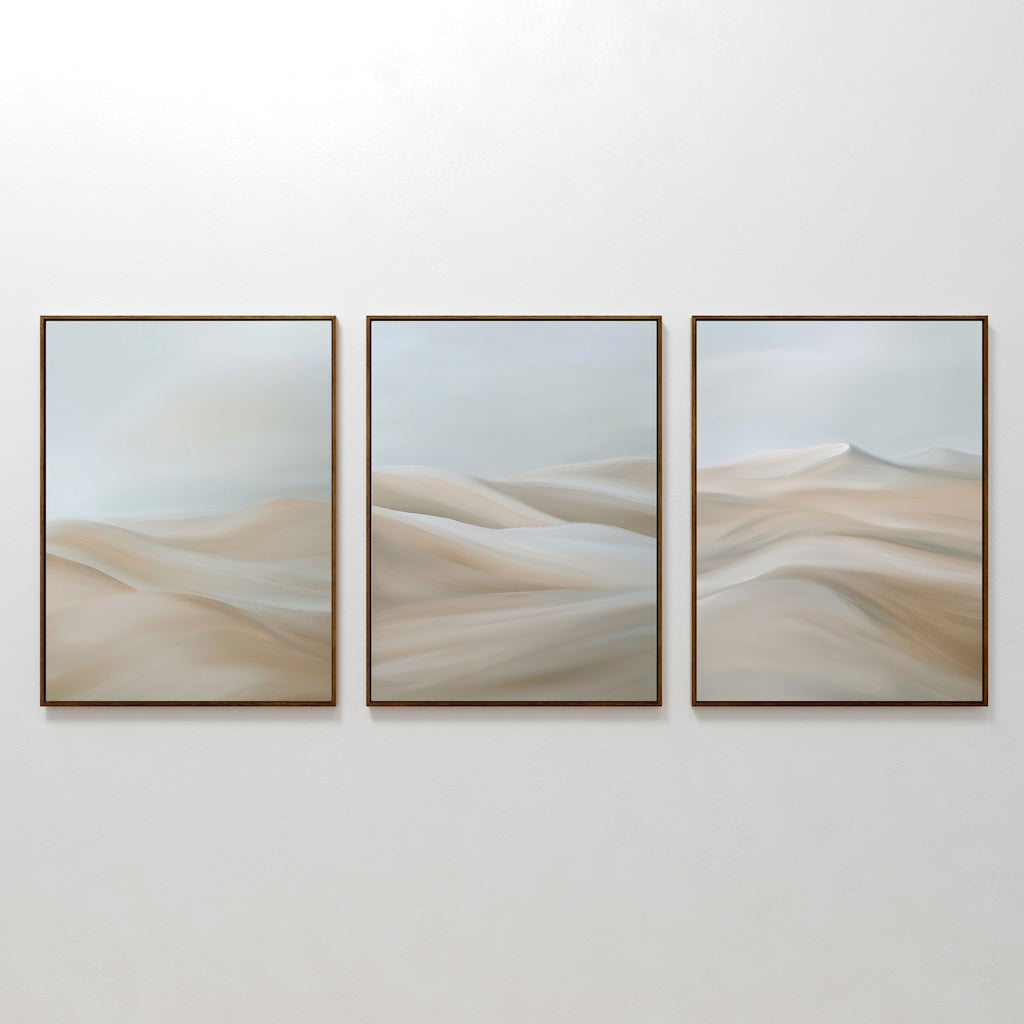 The Desert Serenity Set of 3 features framed abstract paintings with soft beige and light blue shapes, evoking sand dunes or waves—ideal minimalist wall art to enhance your living room decor.