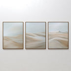 The Desert Serenity Set of 3 features framed abstract paintings with soft beige and light blue shapes, evoking sand dunes or waves—ideal minimalist wall art to enhance your living room decor.