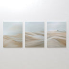 The Desert Serenity Set of 3 features abstract canvas panels with soft beige and light gray desert dunes, mounted side by side—perfect minimalist wall art for your living room.