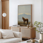 A modern living room in neutral tones displays the Desert Watch Canvas Art on a wooden sideboard, styled with books and vases. A cozy sofa, potted plant, and round light fixture complete this stylish space inspired by Nordic Park design.