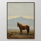 Desert Watch Canvas Art features a framed painting of a chestnut horse on rocky ground with dry grass and distant mountains under a cloudy sky—perfect rustic wall decor to add charm to any room.