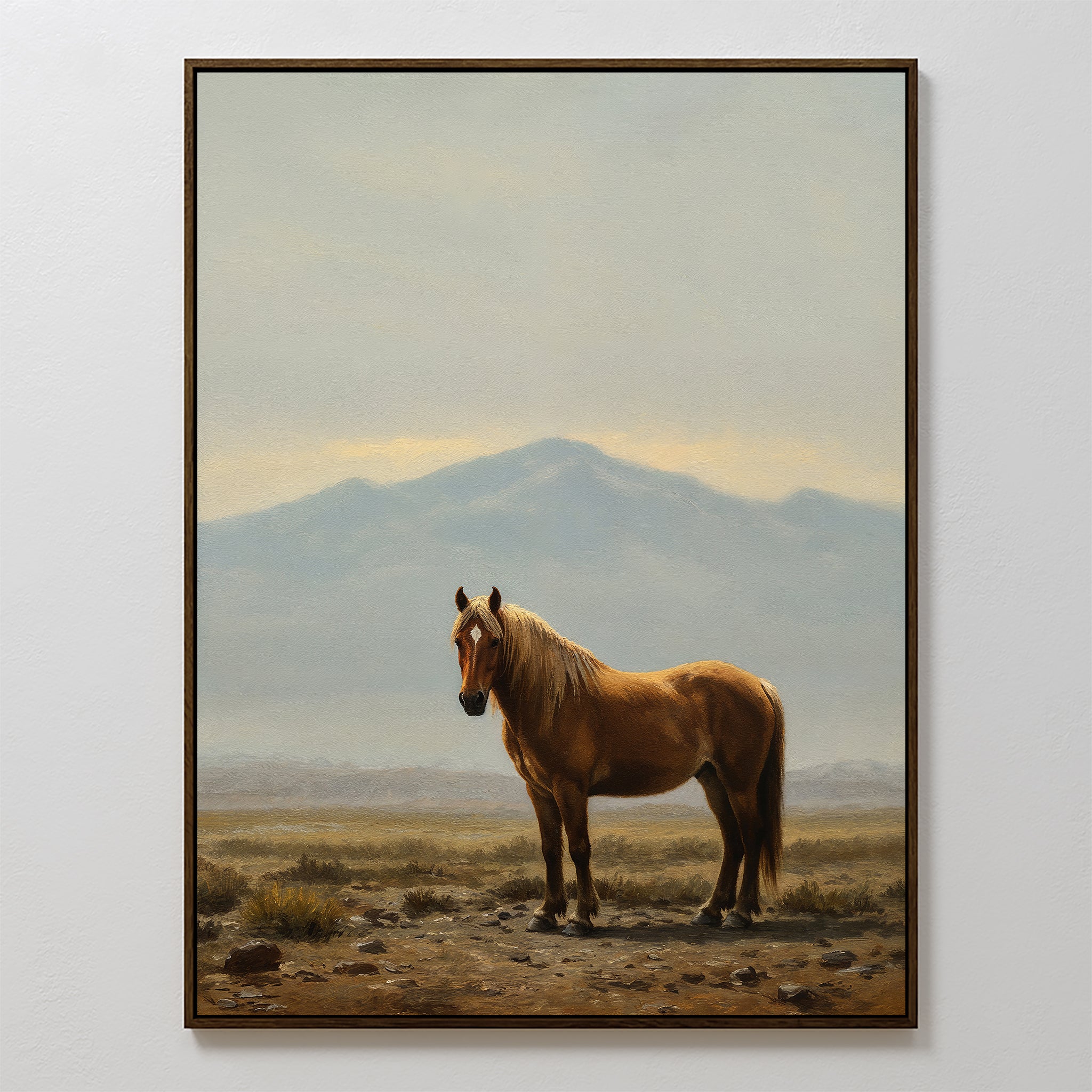 Desert Watch Canvas Art features a framed painting of a chestnut horse on rocky ground with dry grass and distant mountains under a cloudy sky—perfect rustic wall decor to add charm to any room.