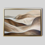 Desert Waves Abstract Canvas Art features rolling hills in beige, brown, and cream with smooth lines and soft gradients. This minimalist wall art comes framed in a slim gold frame against a light gray background.