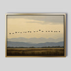 The Distant Flight Canvas Art features birds soaring over grassy fields with blue mountains and a cloudy sky, capturing the serene beauty of Nordic Park.