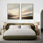 A modern bedroom features a green upholstered bed with white bedding, gold nightstands with beige lamps, and a textured rug. Above the bed hangs the Distant Peaks Set of 2 landscape wall art, adding a minimalist mountain and water vibe.