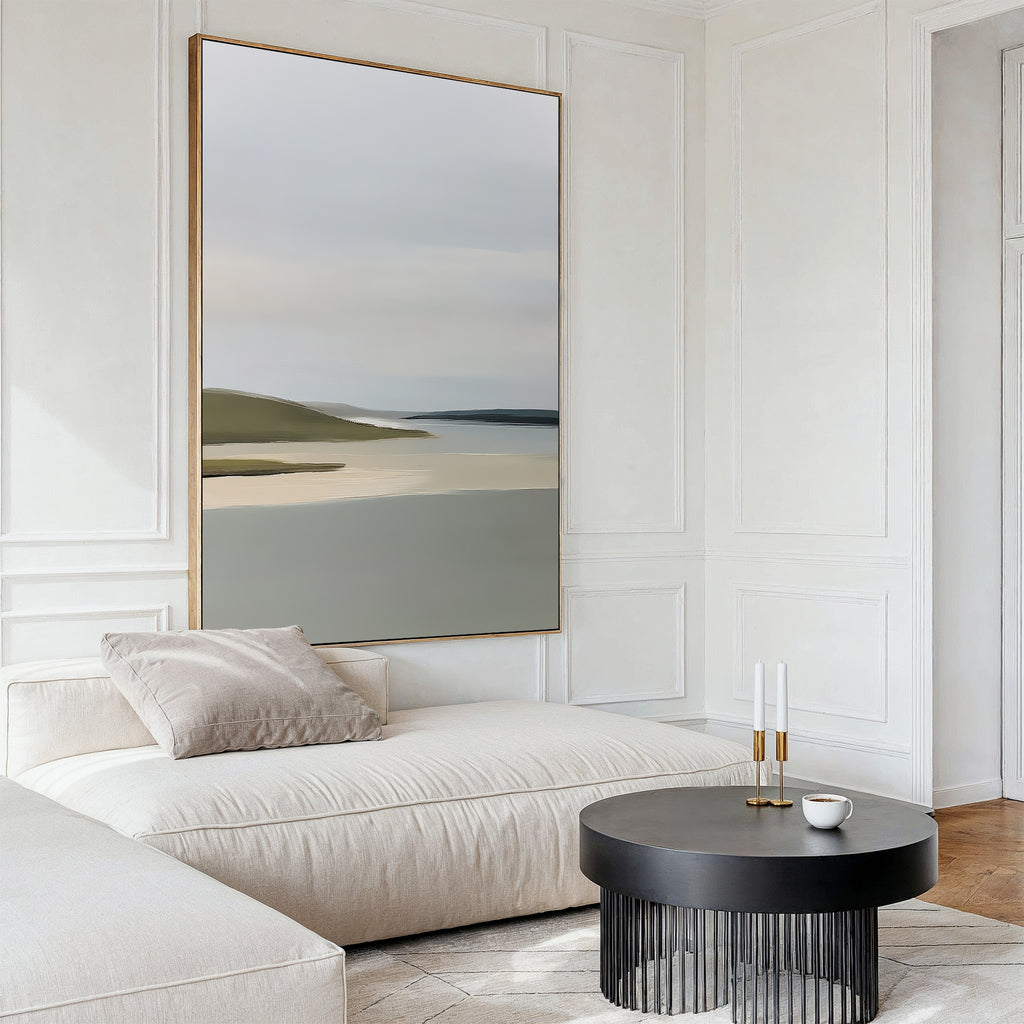 A modern living room showcases the Distant Shores Canvas Art, a minimalist abstract landscape above a white chaise lounge with beige cushion and a round black coffee table, set against white paneled walls and wooden flooring.