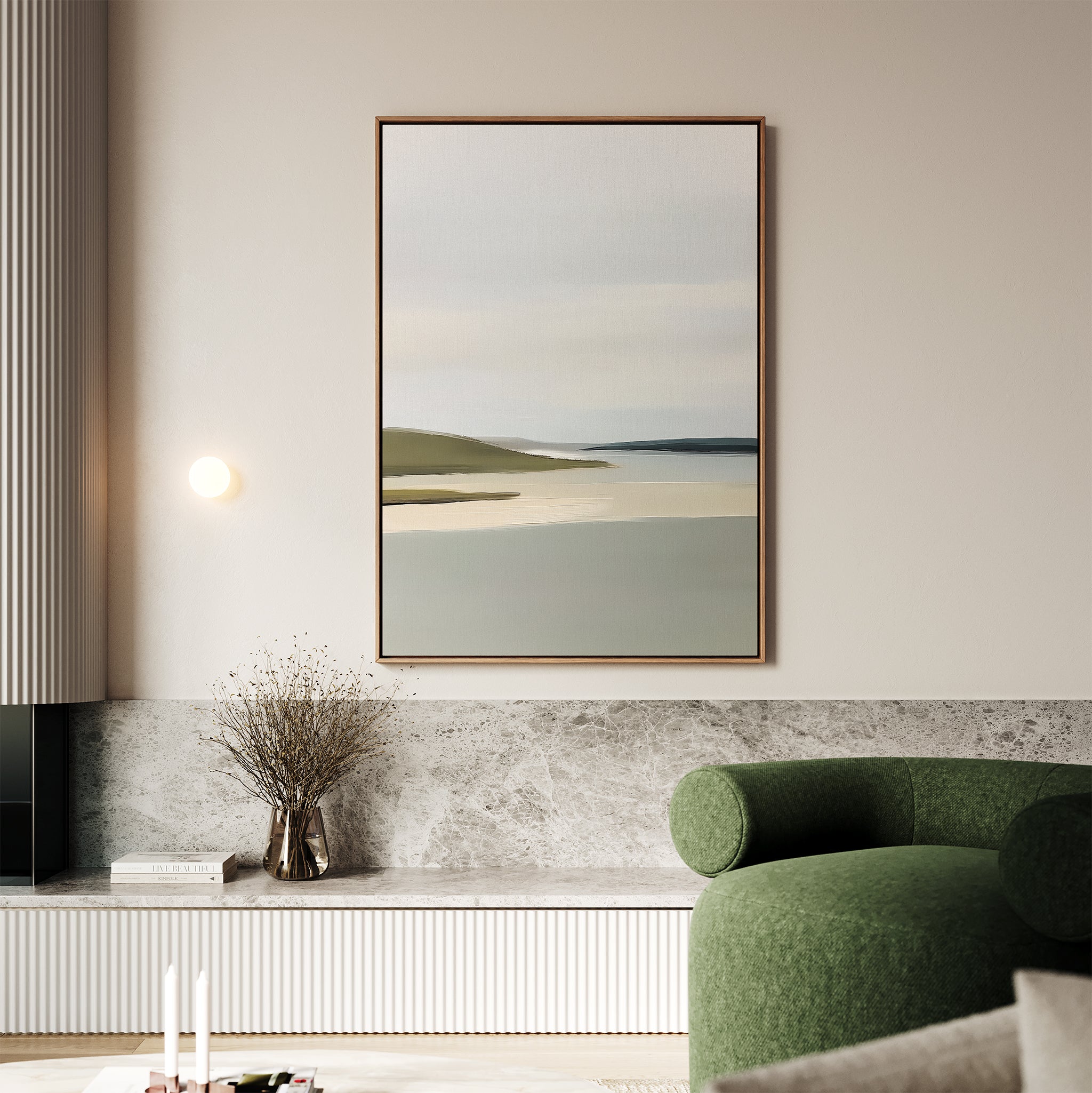 A minimalistic living room features the Distant Shores Canvas Art on a beige wall, a modern sage green armchair, a marble shelf displaying dried flowers in a vase, and gentle natural lighting.
