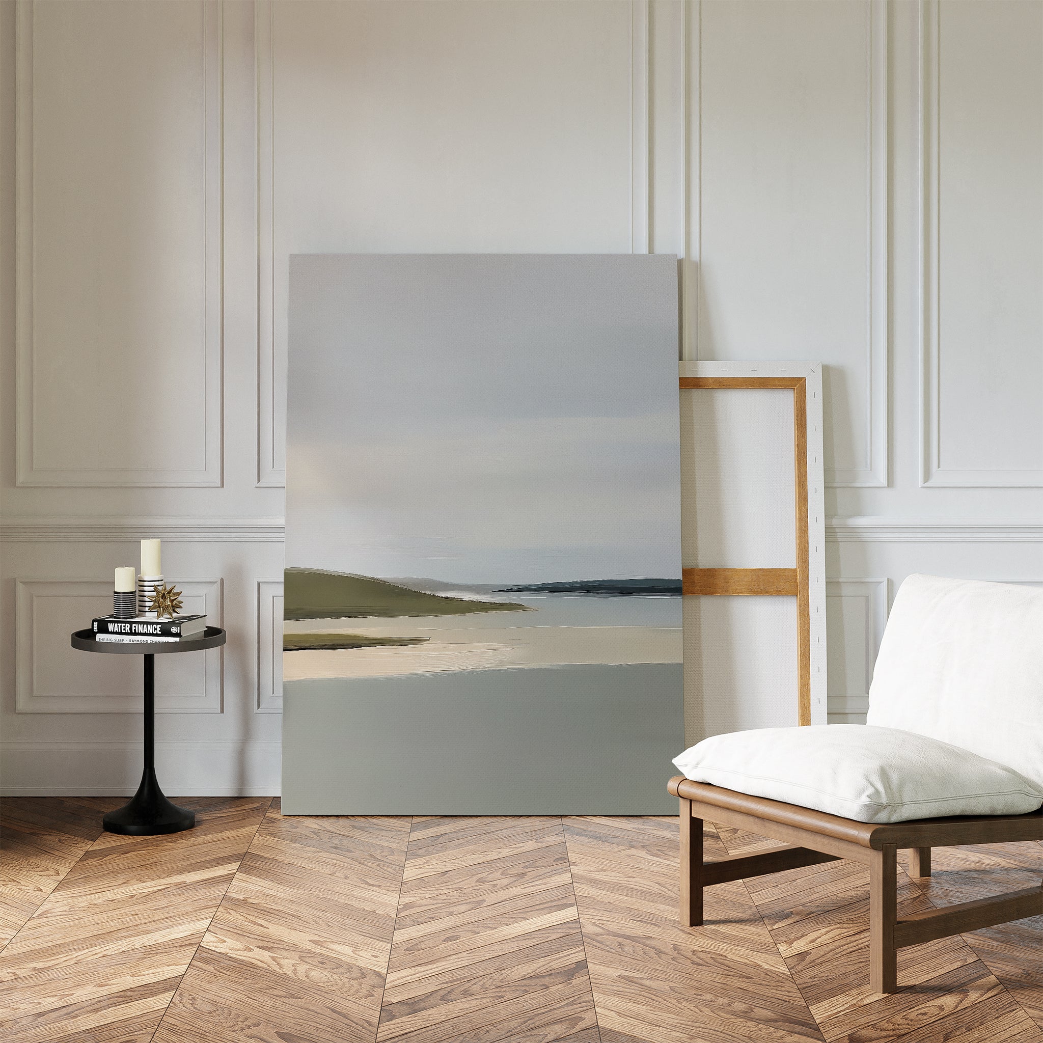 A minimalist room with a patterned wooden floor, white walls, an empty chair with a white cushion, and a black side table holding candles and books. The Distant Shores Canvas Art rests against the wall, adding subtle sophistication.
