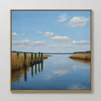 The Dockside Reflection Canvas Art features a tranquil river, tall grasses, a wooden dock extending into the water, and a blue sky with clouds—ideal wall decor for bringing serenity to any room.