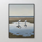 Drifted Calm Canvas Art features a minimalist framed painting of two shorebirds standing in a shallow puddle on a sandy beach, their reflections shimmering—ideal wall art for contemporary interiors and calm coastal spaces.