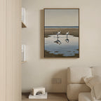 The Drifted Calm Canvas Art, featuring two shorebirds and their reflections, hangs on a beige wall above a light sofa, bringing minimalist style to this contemporary space with shelves displaying books and decor.