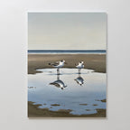 Drifted Calm Canvas Art features two shorebirds by a shallow pool on a sandy beach, their reflections captured against a soft ocean and sky—an ideal minimalist piece to add serene beauty to contemporary interiors.