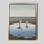 Drifted Calm Canvas Art showcases two seagulls by a sandy beach puddle with their reflections, set against a tranquil sky and ocean. A perfect minimalist piece for coastal interiors.