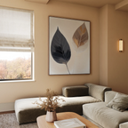 A modern living room with a beige sectional sofa, wooden coffee table with dried flowers, large Dual Leaf Study Canvas Art on the wall, and a window with beige Roman shades letting in natural light.