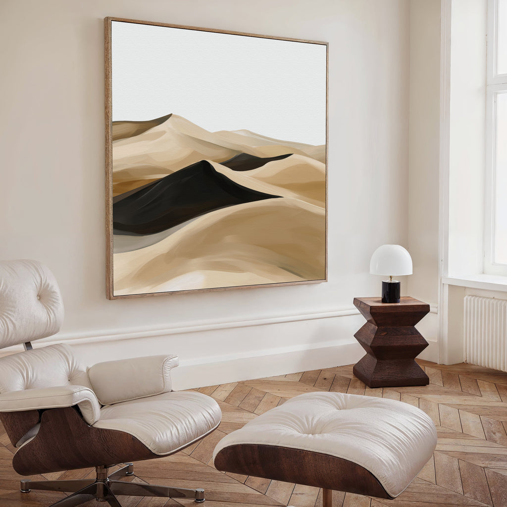 A modern living room features a white leather lounge chair and ottoman, a geometric wooden side table with a white lamp, and Dune Waves Abstract Canvas Art on the wall. Light wood floors and a large window enhance the contemporary decor.