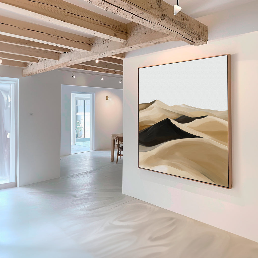 A modern, minimalist interior with white walls and wooden beams features the Dune Waves Abstract Canvas Art—an abstract painting of sand dunes in beige, brown, and black—perfect for contemporary living room decor.