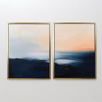 The Dusk Ridge Set of 2 features framed abstract landscape wall art with soft blends of dark blue, peach, orange, and white tones, evoking a tranquil seascape—ideal for serene bedroom decor.