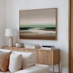 A modern living room with a light wood sideboard, neutral decor, stacked books, a white lamp, and large wall decor—Earthbound Horizon Canvas Art in soft earth tones—hanging above.