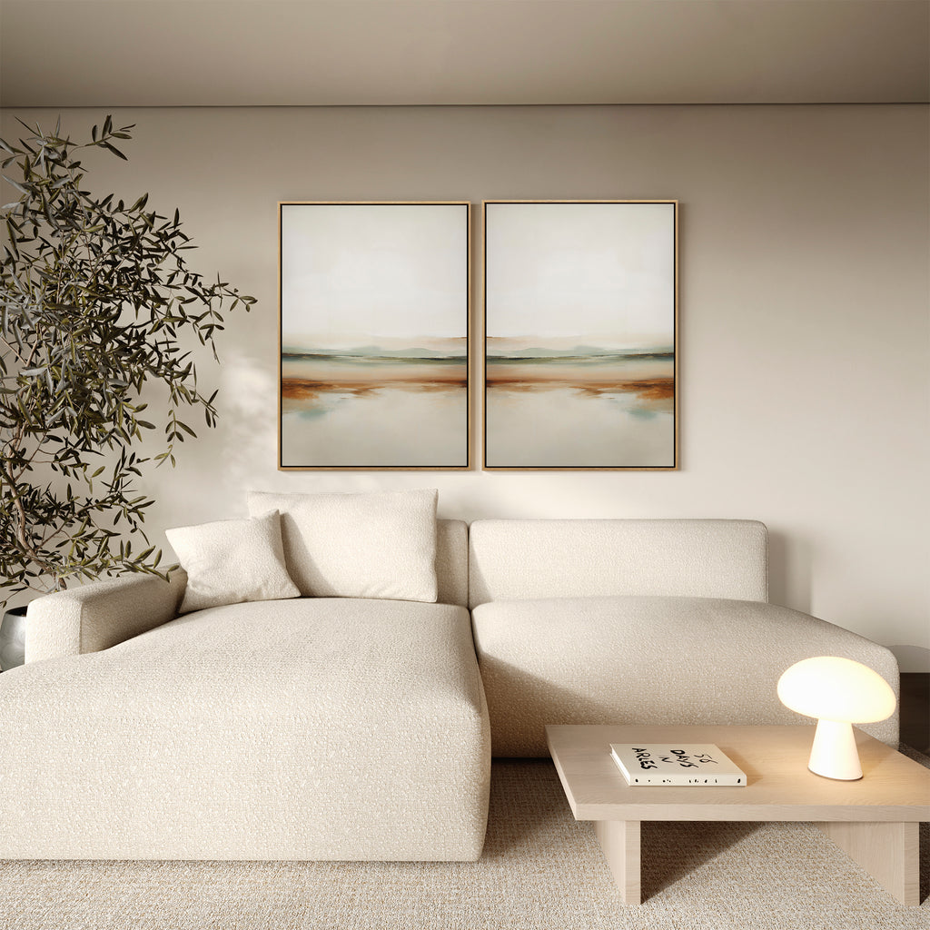 A modern living room with a cream chaise sofa, wooden coffee table, small lamp and book, minimalist "Earthly Hues Set of 2" wall art as an abstract diptych, and a leafy indoor plant in the corner completes the decor.