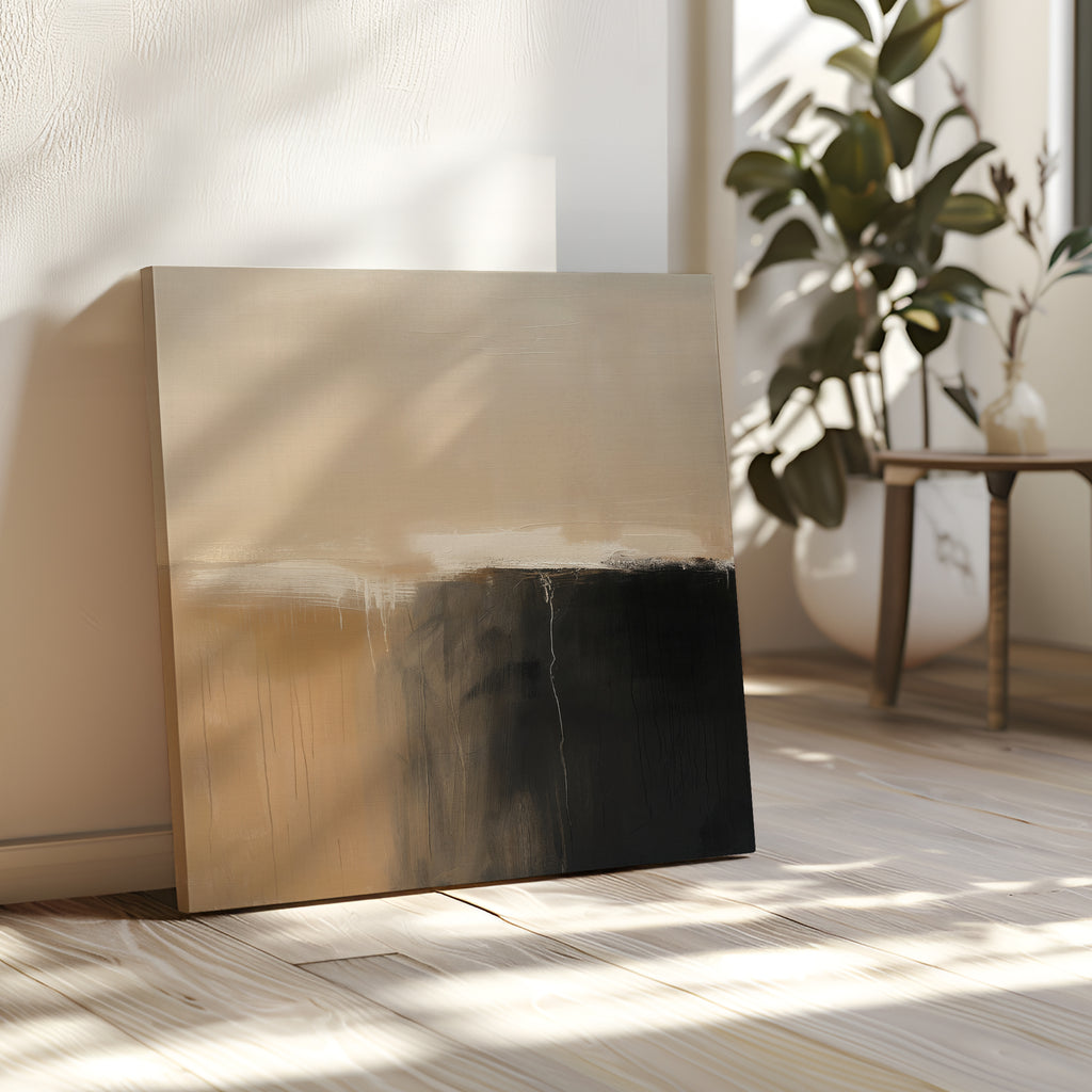 The Earthy Cliffs Abstract Canvas Art, with beige and black tones, leans against a sunlit wall on a wooden floor, complementing your living room decor near a green plant and a small table with a vase.