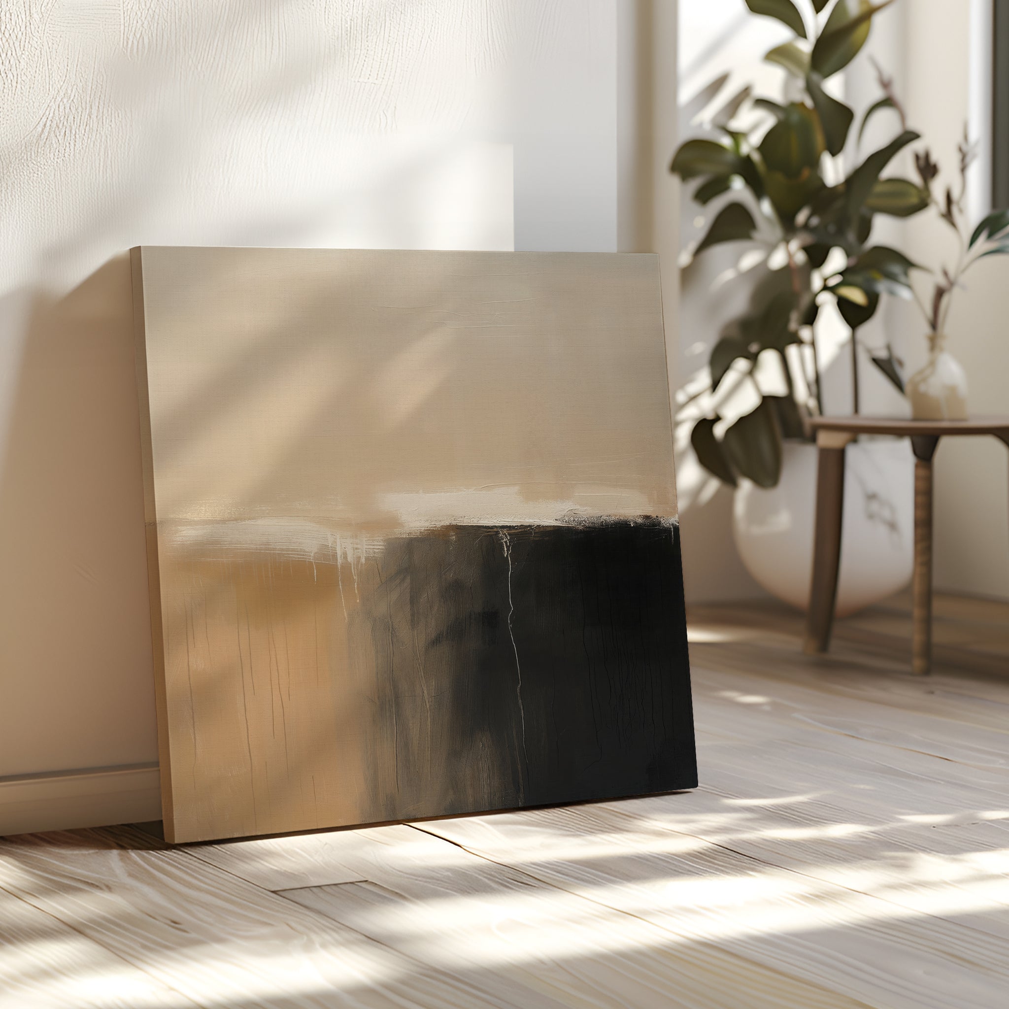 The Earthy Cliffs Abstract Canvas Art, with beige and black tones, leans against a sunlit wall on a wooden floor, complementing your living room decor near a green plant and a small table with a vase.