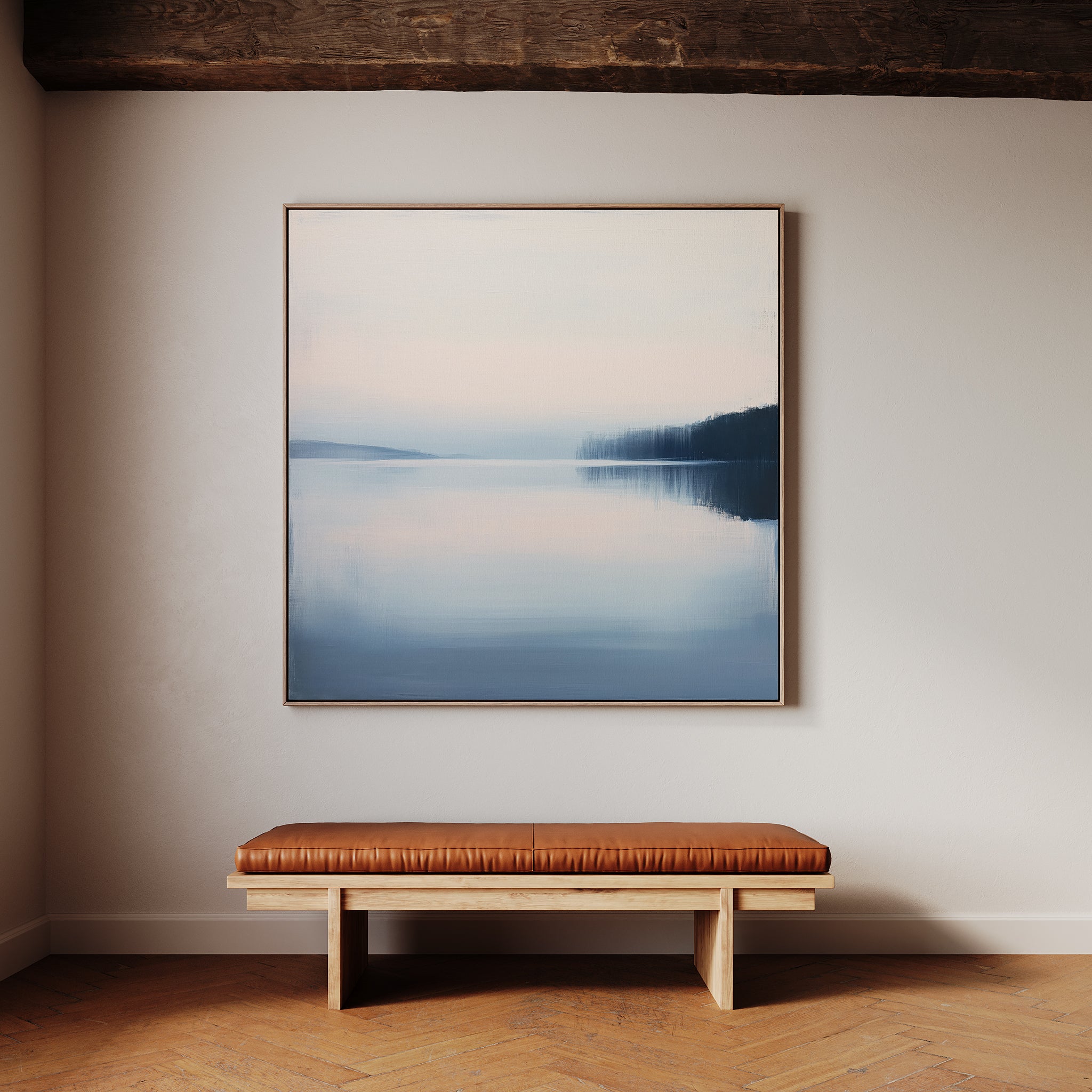 A minimalist room features a wooden bench with a brown leather cushion below Echo Lake Canvas Art, a large framed lake scene with soft blue and pink tones, hanging on a light-colored wall.